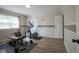 Spacious exercise room with wood floors featuring exercise equipment and natural light from the bright window at 11458 Falling Water Way, Fishers, IN 46037