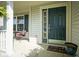 Cozy front porch featuring an elegant dark front door and a sitting area with a small table at 11458 Falling Water Way, Fishers, IN 46037