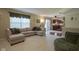 Open living room with large sectional, opening into kitchen, and natural light at 11458 Falling Water Way, Fishers, IN 46037