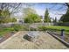Brick patio with a cozy fire pit and a bench offers a charming outdoor retreat, framed by mature trees at 11458 Falling Water Way, Fishers, IN 46037