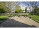 Spacious brick patio with a fire pit and bench seating, perfect for outdoor gatherings in a serene backyard setting at 11458 Falling Water Way, Fishers, IN 46037