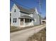 Charming two-story home featuring light blue siding, a covered front porch, and a well-maintained yard at 117 N 10Th St, Elwood, IN 46036