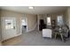 Cozy living room featuring neutral walls, plush carpet, and access to the staircase and other rooms at 117 N 10Th St, Elwood, IN 46036