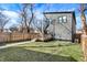 View of the home's backyard with a wooden deck, fenced yard, and gray siding at 1209 N Rural St, Indianapolis, IN 46201