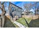 View of the home's backyard with a wooden deck, fenced yard, and gray siding at 1209 N Rural St, Indianapolis, IN 46201