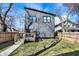 View of the home's backyard with a wooden deck, fenced yard, and gray siding at 1209 N Rural St, Indianapolis, IN 46201