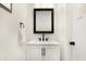Modern bathroom vanity with white countertop, black fixtures, and a framed mirror at 1209 N Rural St, Indianapolis, IN 46201