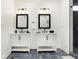 Stylish bathroom featuring dual vanities with black fixtures and a glass-enclosed tiled shower at 1209 N Rural St, Indianapolis, IN 46201