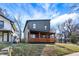 Modern two-story home featuring a front porch with vibrant orange-stained wood and unique architectural design at 1209 N Rural St, Indianapolis, IN 46201