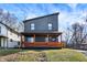Modern two-story home featuring a front porch with vibrant orange-stained wood and unique architectural design at 1209 N Rural St, Indianapolis, IN 46201