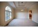 Bright living room featuring a large window, tray ceiling, and carpet floors at 12348 Seaway Cir, Indianapolis, IN 46236