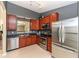 Well-lit kitchen featuring stainless steel appliances and plentiful dark wood cabinetry at 1269 Frogs Leap, Cicero, IN 46034