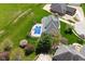 Lush lawn surrounds this home with a pool and a diving board, viewed from above on a sunny day at 1358 Rutherglen Ct, Danville, IN 46122