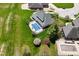 Expansive aerial view of a home with an in-ground pool surrounded by a lush green lawn and blossoming trees at 1358 Rutherglen Ct, Danville, IN 46122