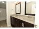Dark wood bathroom vanity with double sinks, gray countertop, framed mirrors, and silver hardware at 1358 Rutherglen Ct, Danville, IN 46122