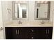 Well-lit bathroom featuring double sinks with stylish fixtures and dark wood cabinets at 1358 Rutherglen Ct, Danville, IN 46122