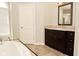 Well-lit bathroom with a dark vanity, large mirror and a bathtub with tile surround at 1358 Rutherglen Ct, Danville, IN 46122