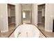 Bright bathroom featuring a large soaking tub with walk in closets and neutral tones at 1358 Rutherglen Ct, Danville, IN 46122