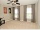 A bright bedroom with three windows and gray curtains features a ceiling fan and neutral carpet at 1358 Rutherglen Ct, Danville, IN 46122