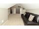 Large carpeted bonus room featuring a dark brown leather sofa and two closets at 1358 Rutherglen Ct, Danville, IN 46122