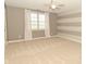 Bedroom with light carpet, and gray and white striped wall, features a window and a ceiling fan at 1358 Rutherglen Ct, Danville, IN 46122
