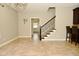Bright dining room with a chandelier, large windows, and tile flooring leading to a staircase at 1358 Rutherglen Ct, Danville, IN 46122