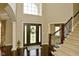 Bright foyer featuring dark wood floors, staircase and a large front door with glass inserts at 1358 Rutherglen Ct, Danville, IN 46122