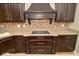 Stylish kitchen with custom cabinets, cooktop, and tiled backsplash offers a blend of design and functionality at 1358 Rutherglen Ct, Danville, IN 46122