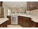 Kitchen showcasing stainless steel dishwasher and sink complemented by custom wood cabinetry at 1358 Rutherglen Ct, Danville, IN 46122