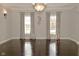 Bright living room features hardwood floors, large windows with curtains, and an elegant chandelier at 1358 Rutherglen Ct, Danville, IN 46122
