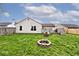 Fenced-in backyard with a brick fire pit, green grass, and a well-maintained lawn at 1378 Millridge Dr, Greenwood, IN 46143