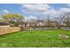 Expansive backyard with lush green grass, a brick fire pit, and a secure wooden fence at 1378 Millridge Dr, Greenwood, IN 46143