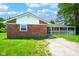 Charming brick home with a covered front porch, grassy yard, and sunny sky at 1509 E Centennial Ave, Muncie, IN 47303