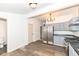 Updated kitchen features stainless steel appliances, grey cabinetry and modern light fixture at 1521 Lawton Ave, Indianapolis, IN 46203