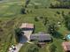Aerial view of property featuring a charming home, spacious garage, and pool, set within a lush landscape at 15415 E 146Th St, Noblesville, IN 46060