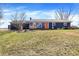 Charming single-story home with a cozy front porch and inviting orange door, surrounded by a well-maintained lawn at 15415 E 146Th St, Noblesville, IN 46060