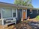View of front deck with bench seating, accent pillows, string lights, and a vibrant orange front door at 15415 E 146Th St, Noblesville, IN 46060
