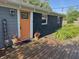 Charming front porch with an orange door, string lights, and lush landscaping at 15415 E 146Th St, Noblesville, IN 46060