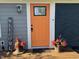 Vibrant orange front door flanked by decorative planters, 'Welcome' sign and modern light fixture at 15415 E 146Th St, Noblesville, IN 46060