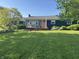 Charming single story home with a well-manicured lawn, deck, orange door, and inviting curb appeal at 15415 E 146Th St, Noblesville, IN 46060