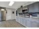 Spacious kitchen with stainless steel refrigerator, grey cabinets, and modern countertops at 15415 E 146Th St, Noblesville, IN 46060