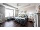 Bright bedroom featuring a tray ceiling, hardwood floors, and modern furnishings at 16164 Loire Valley Dr, Fishers, IN 46037