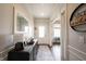 Elegant entryway with hardwood floors, stylish console table, and decorative mirror creating a welcoming ambiance at 16164 Loire Valley Dr, Fishers, IN 46037