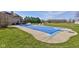 An expansive backyard with a covered in-ground pool, diving board, large patio, and green lawn at 2274 W Huntsville Rd, Pendleton, IN 46064