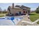 Brick home featuring a covered pool, patio with seating, and expansive yard for outdoor living and recreation at 2274 W Huntsville Rd, Pendleton, IN 46064