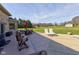 A spacious backyard with an outdoor dining table, patio seating, lush green grass and mature trees at 2274 W Huntsville Rd, Pendleton, IN 46064