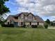 Charming two-story brick home with a well-manicured lawn, blue front door, and beautiful landscaping at 2274 W Huntsville Rd, Pendleton, IN 46064