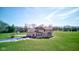 A rear elevation view of a brick home with an in-ground pool, a patio, and a sprawling lawn at 2274 W Huntsville Rd, Pendleton, IN 46064