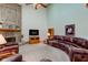 Spacious living room with brick fireplace, leather wrap around sofa, vaulted ceilings, and abundant natural light at 2274 W Huntsville Rd, Pendleton, IN 46064