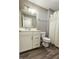 Bathroom with wood look floor, a white vanity and hardware, a large mirror, and a shower/tub at 2326 Saddle Dr, Shelbyville, IN 46176